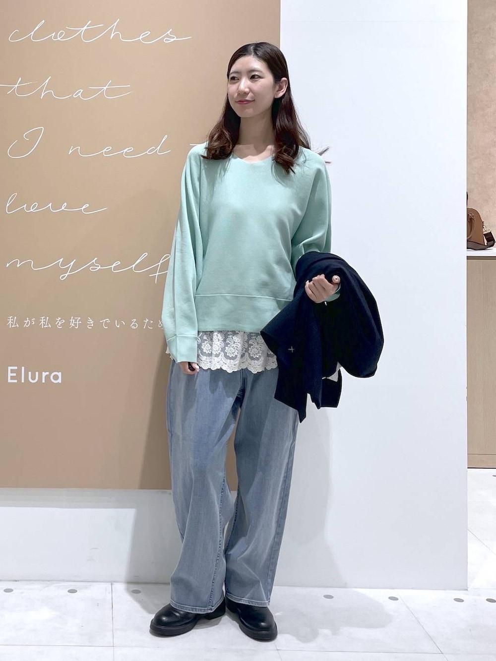 ホワイト系のタンクトップ、ブルー系のデニムパンツ、ブルー系のテーラードジャケットを着用したレディースの春コーディネートの4枚目の写真