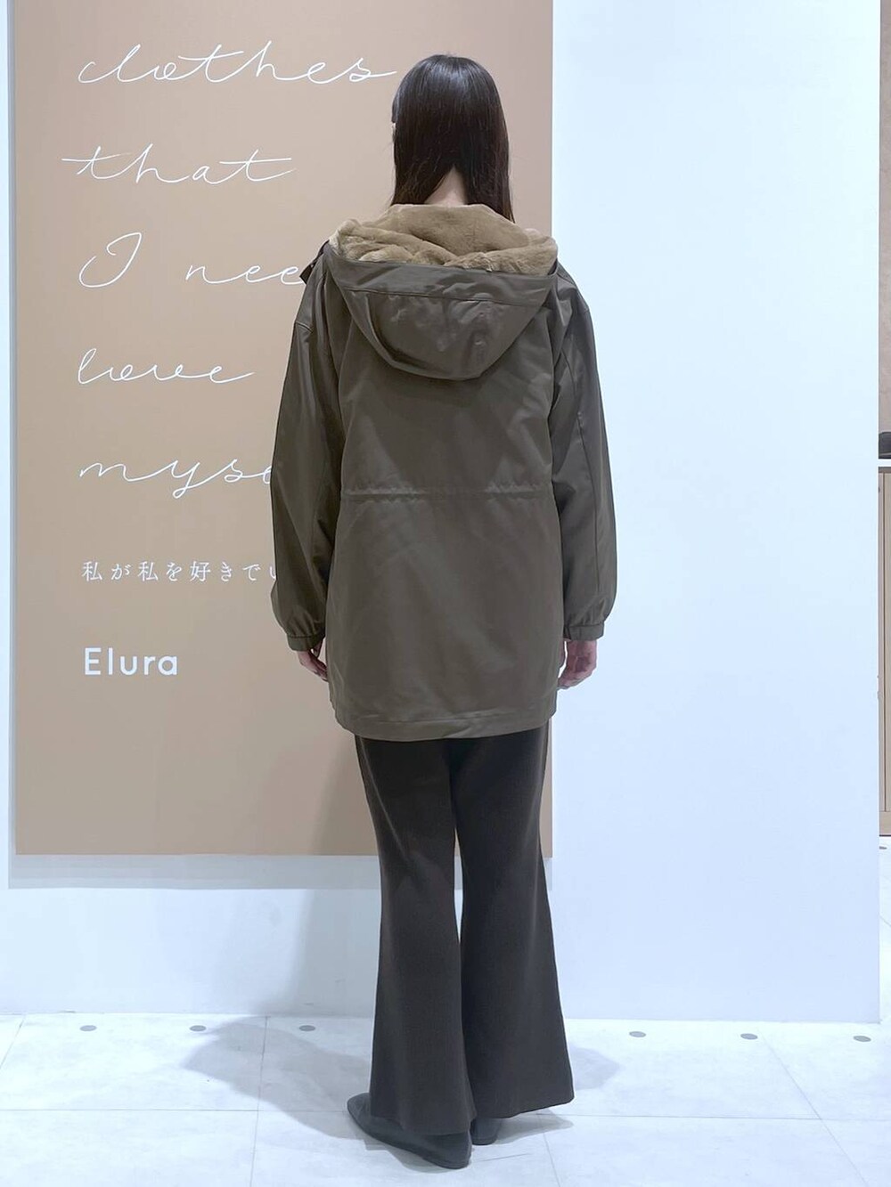 ホワイト系のタンクトップ、イエロー系のニット/セーター、ブラウン系のマウンテンパーカーを着用したレディースの秋コーディネートの3枚目の写真