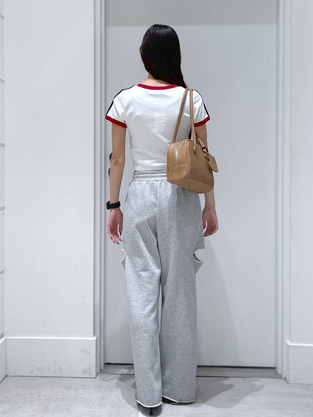 ブルー系のショルダーバッグ、グレー系のスウェットパンツ、ブラック系のパンプスを着用したレディースの春コーディネートの3枚目の写真