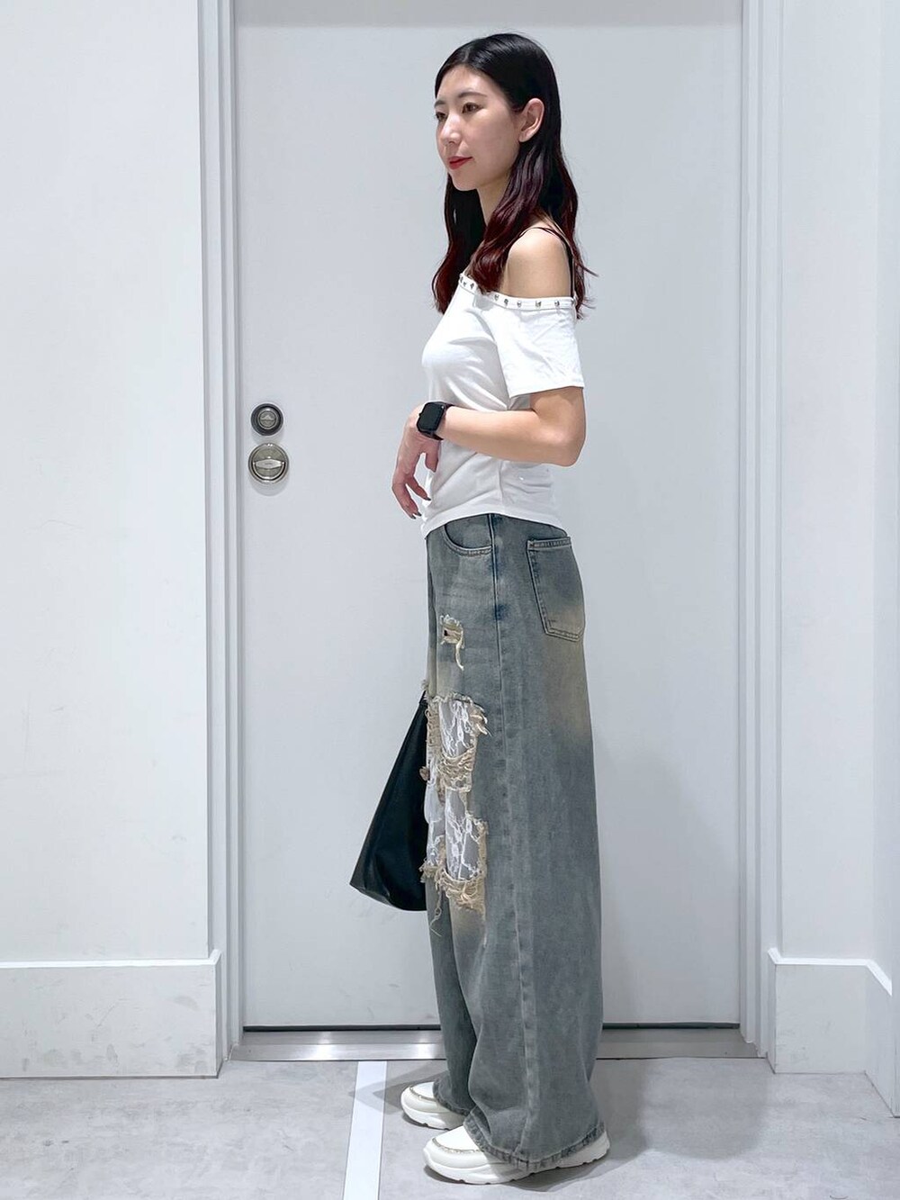 ブルー系のデニムパンツ、ブラック系のショルダーバッグ、ホワイト系のTシャツ/カットソーを着用したレディースの夏コーディネートの2枚目の写真