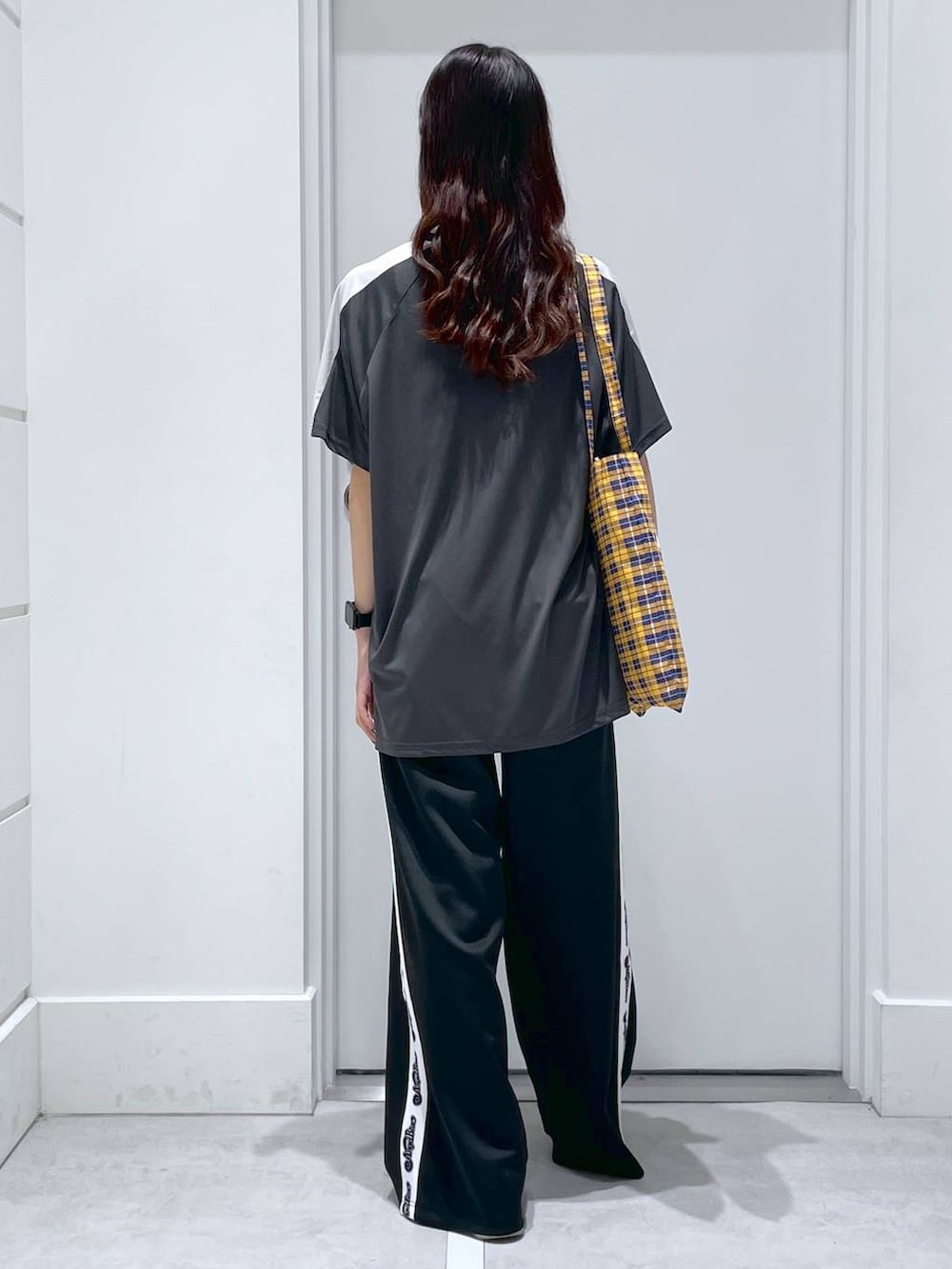 ブラック系のその他パンツ、ブラック系のTシャツ/カットソー、イエロー系のトートバッグを着用したレディースの春コーディネートの3枚目の写真