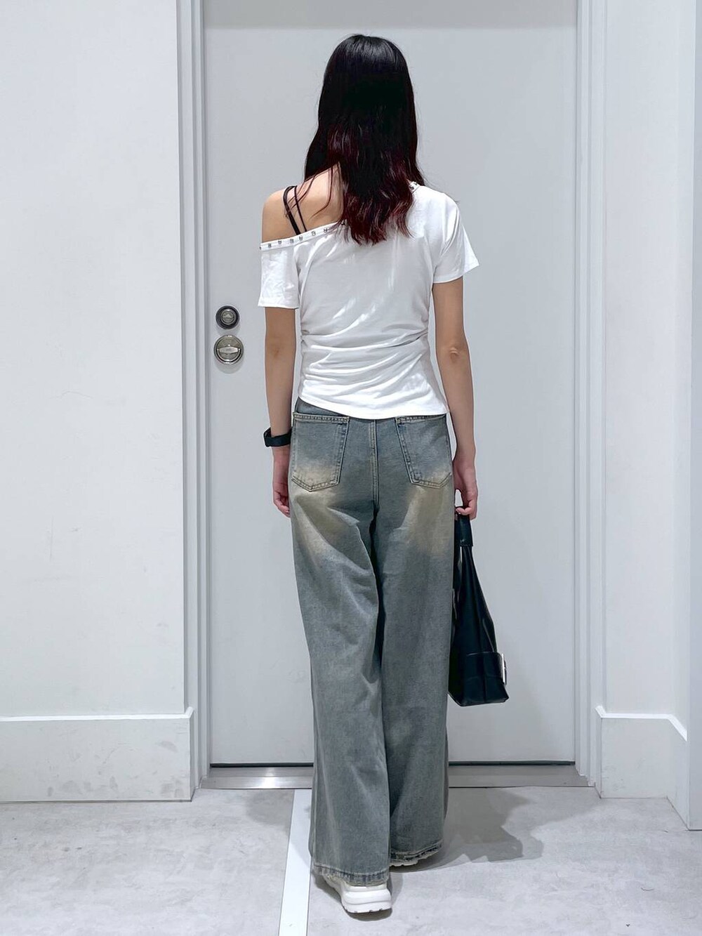 ブルー系のデニムパンツ、ブラック系のショルダーバッグ、ホワイト系のTシャツ/カットソーを着用したレディースの夏コーディネートの3枚目の写真