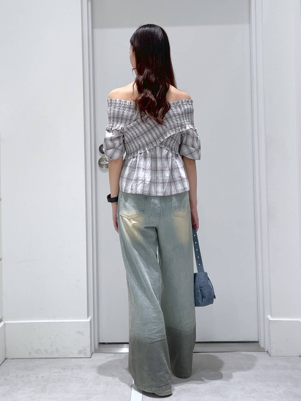 ブルー系のショルダーバッグ、ブルー系のデニムパンツ、グレー系のシャツ/ブラウスを着用したレディースの春コーディネートの3枚目の写真