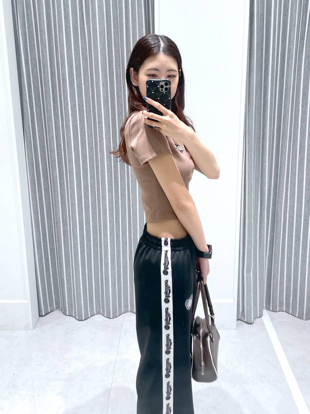 ブラウン系のボストンバッグ、ブラック系のその他パンツ、ベージュ系のTシャツ/カットソーを着用したレディースの春コーディネートの3枚目の写真