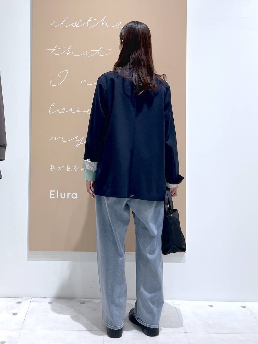 ホワイト系のタンクトップ、ブルー系のデニムパンツ、ブルー系のテーラードジャケットを着用したレディースの春コーディネートの2枚目の写真