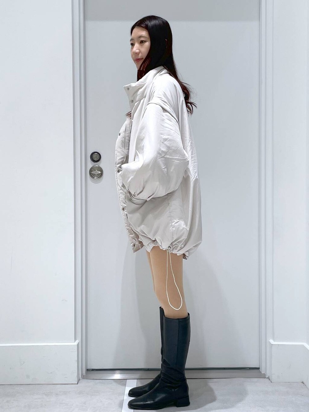 ホワイト系のブルゾン、ホワイト系のその他パンツ、ブラック系のニット/セーターを着用したレディースの冬コーディネートの2枚目の写真