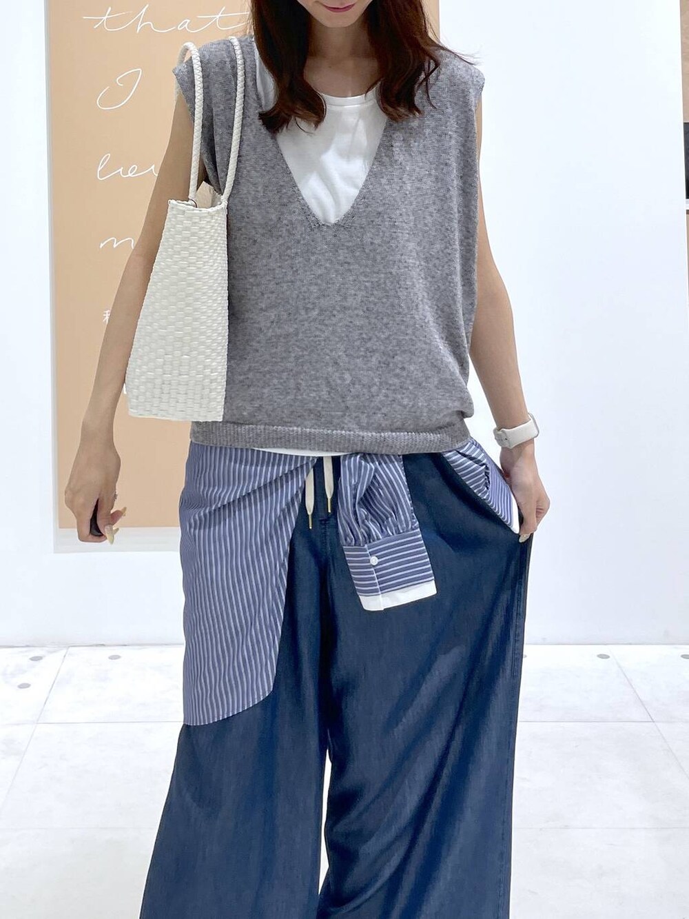 ブルー系のデニムパンツ、ブルー系のシャツ/ブラウス、ホワイト系のかごバッグを着用したレディースの夏コーディネートの4枚目の写真