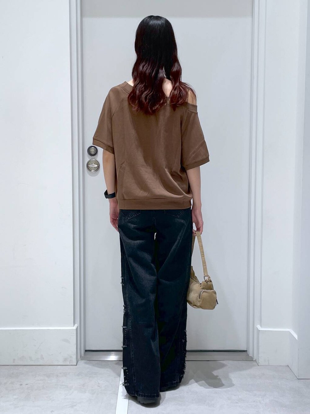 ブラック系のデニムパンツ、ブラウン系のセットアップ、ブラウン系のハンドバッグを着用したレディースの夏コーディネートの3枚目の写真