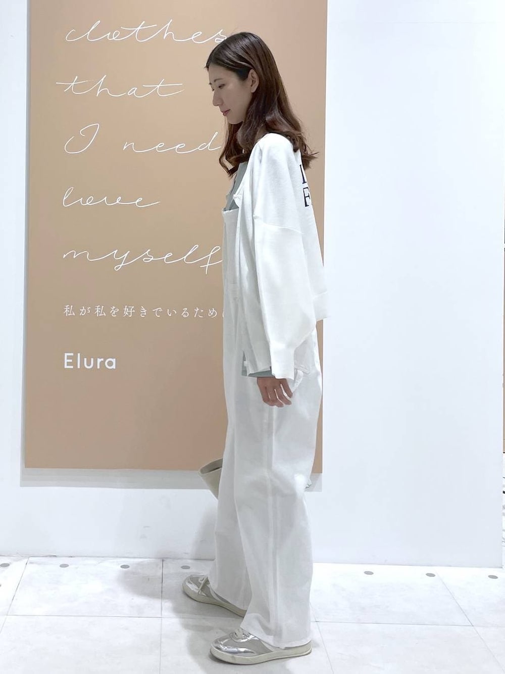 ブルー系のトートバッグ、グリーン系のシャツ/ブラウス、ホワイト系のサロペット/オーバーオールを着用したレディースの春コーディネートの2枚目の写真