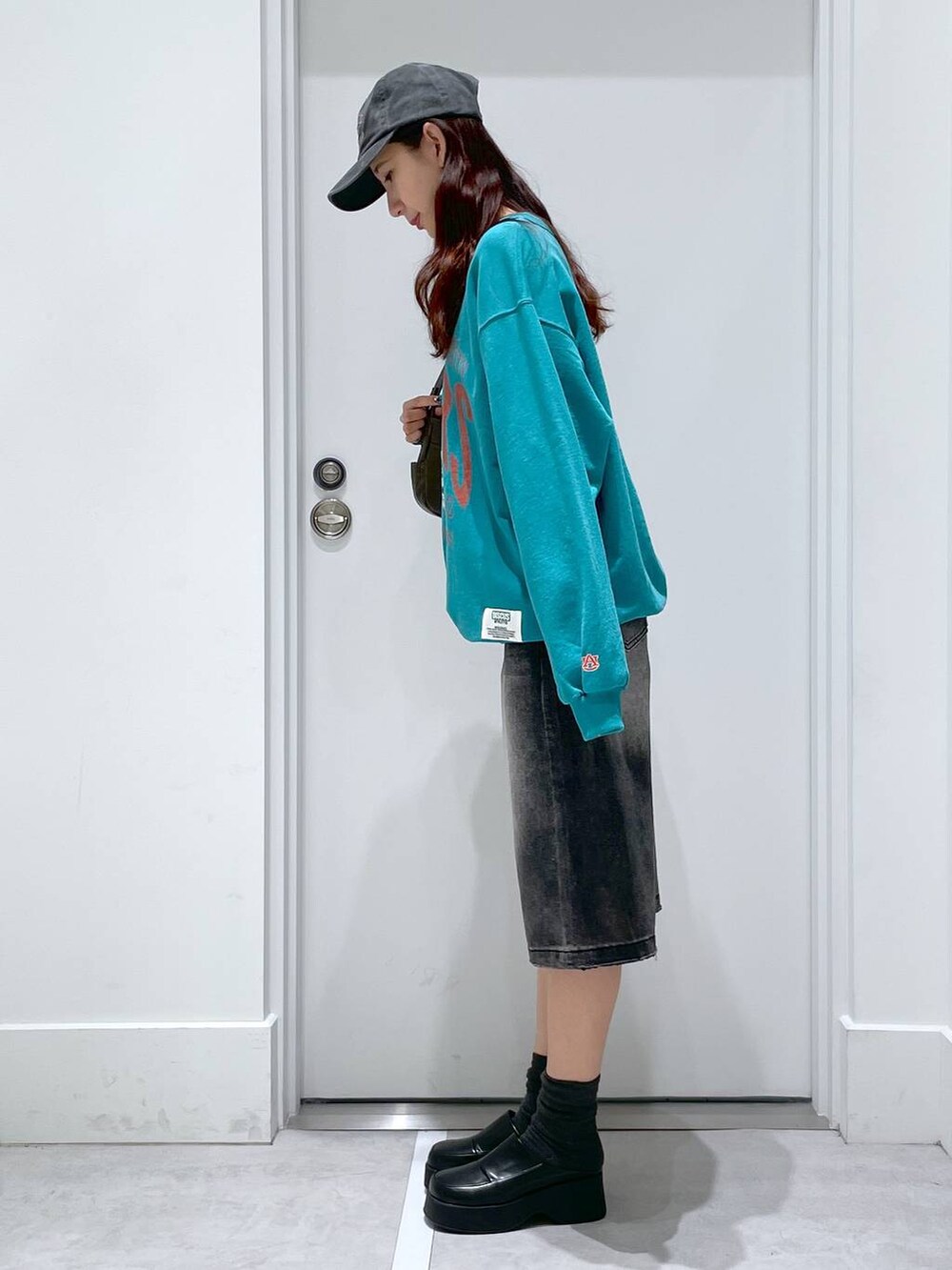 ブラック系のスリッポン、グレー系のスウェット、ブラック系のデニムパンツを着用したレディースの冬コーディネートの2枚目の写真