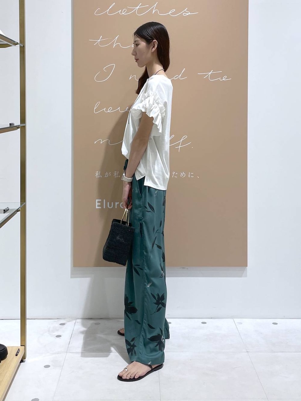 グリーン系のその他パンツ、ブラック系のトートバッグ、ホワイト系のTシャツ/カットソーを着用したレディースの夏コーディネートの2枚目の写真