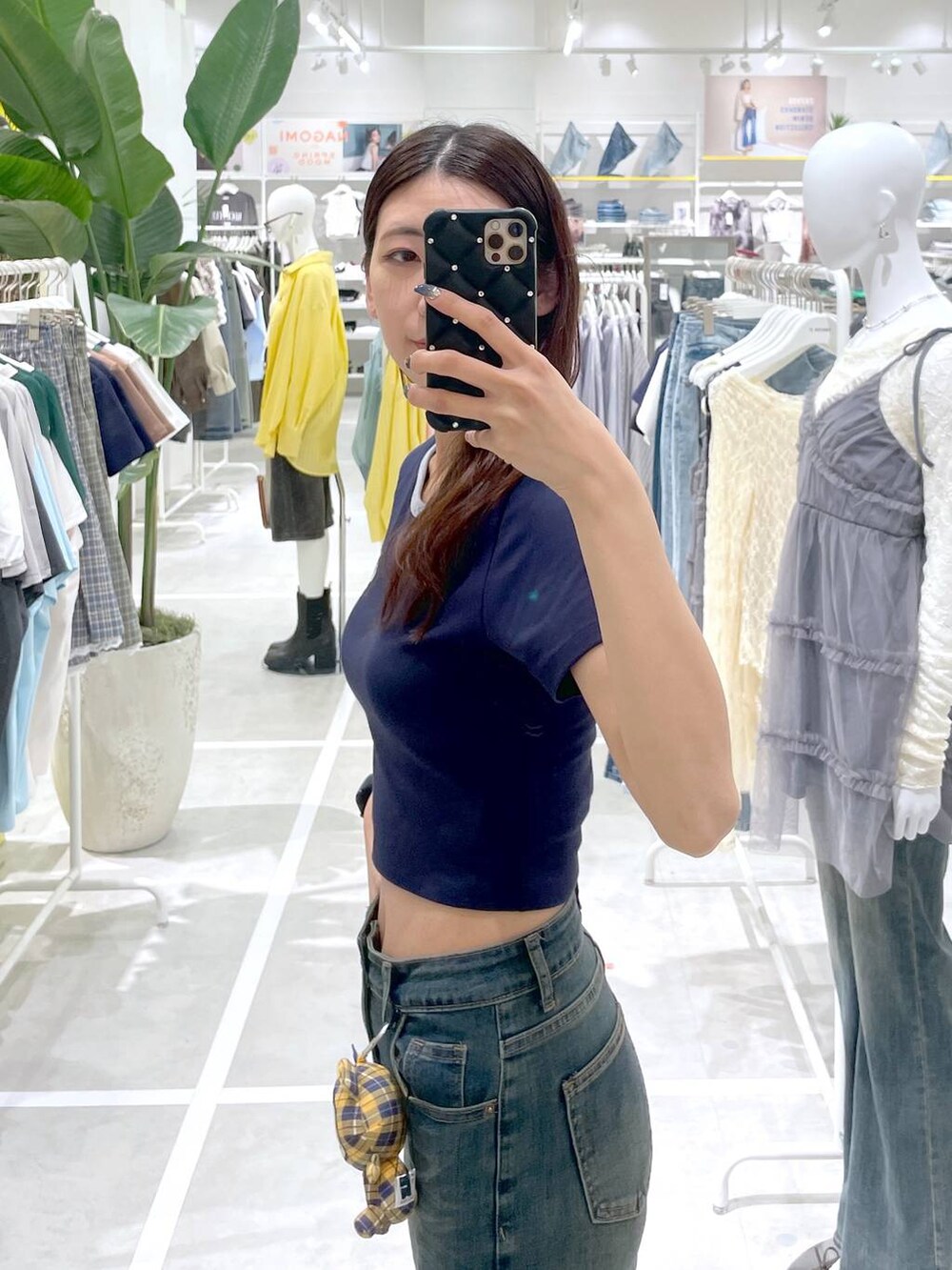ブルー系のデニムパンツ、ブルー系のTシャツ/カットソー、イエロー系のチャームを着用したレディースの春コーディネートの3枚目の写真
