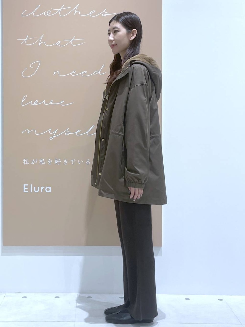 ホワイト系のタンクトップ、イエロー系のニット/セーター、ブラウン系のマウンテンパーカーを着用したレディースの秋コーディネートの2枚目の写真