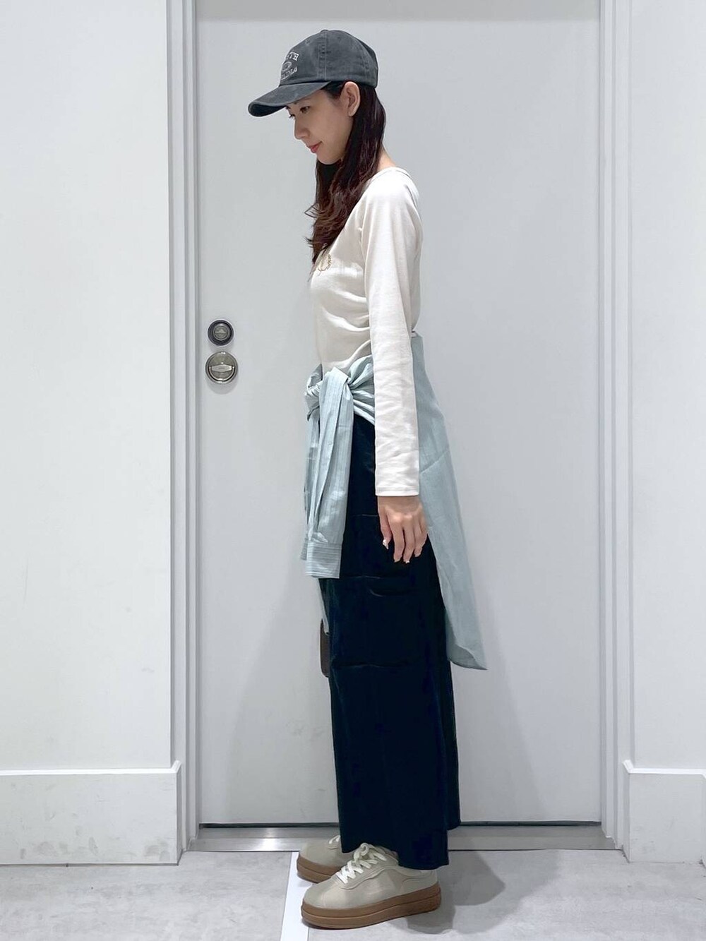 グリーン系のシャツ/ブラウス、ブラック系のスカート、ホワイト系のTシャツ/カットソーを着用したレディースの春コーディネートの2枚目の写真