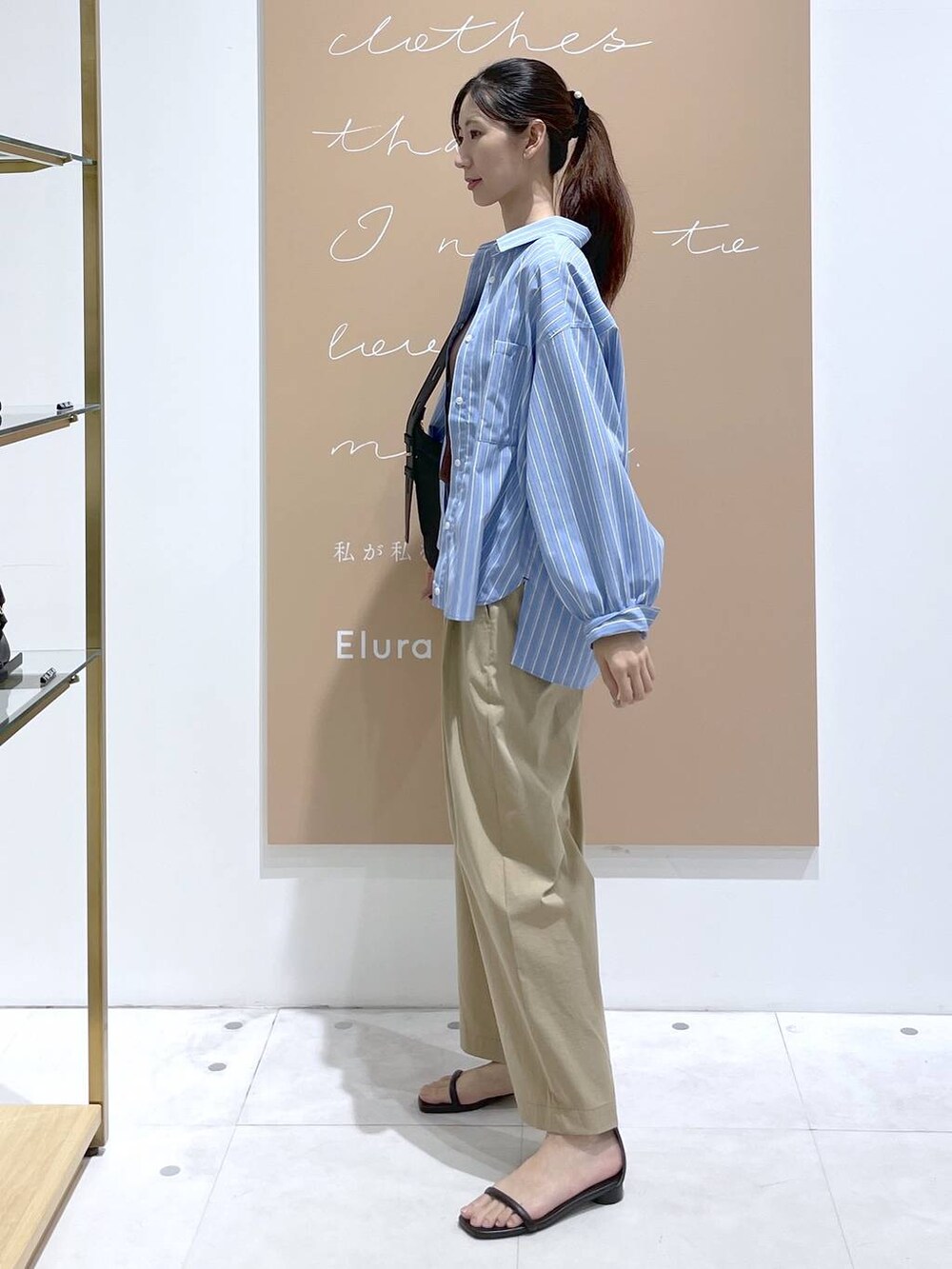 ブラック系のショルダーバッグ、ベージュ系のその他パンツ、ブルー系のシャツ/ブラウスを着用したレディースの秋コーディネートの2枚目の写真