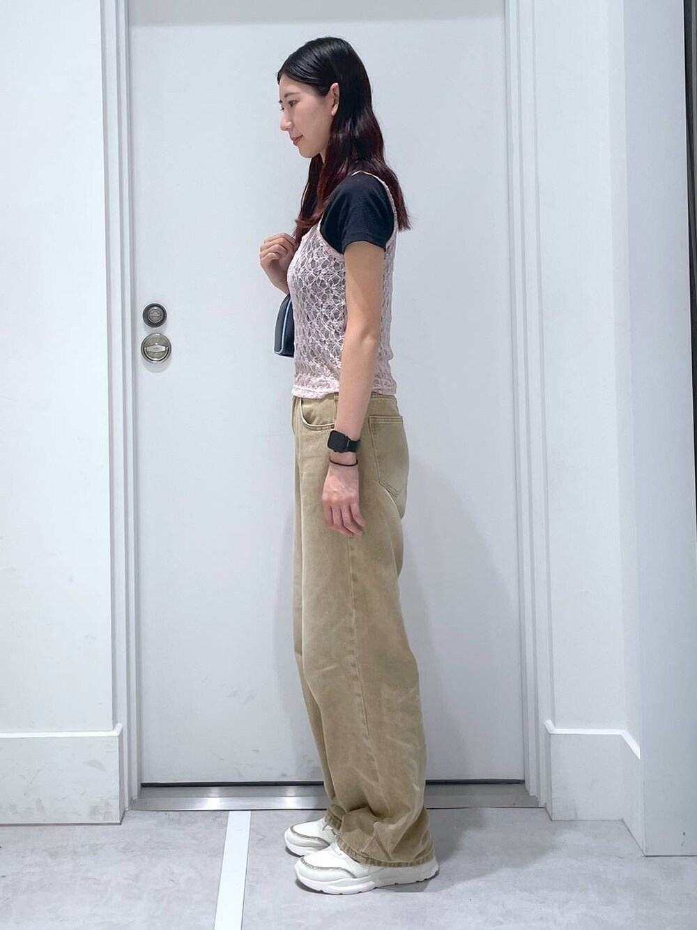 ブルー系のボストンバッグ、ブラック系のTシャツ/カットソー、ブラウン系のデニムパンツを着用したレディースの夏コーディネートの2枚目の写真