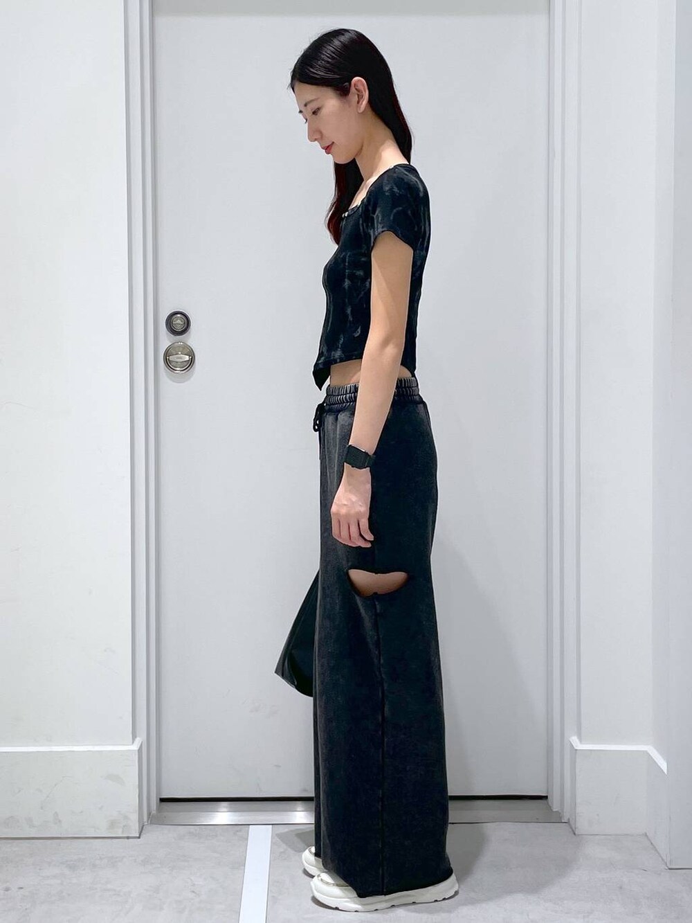 ブラック系のスウェットパンツ、ブラック系のショルダーバッグ、ブラック系のTシャツ/カットソーを着用したレディースの夏コーディネートの2枚目の写真