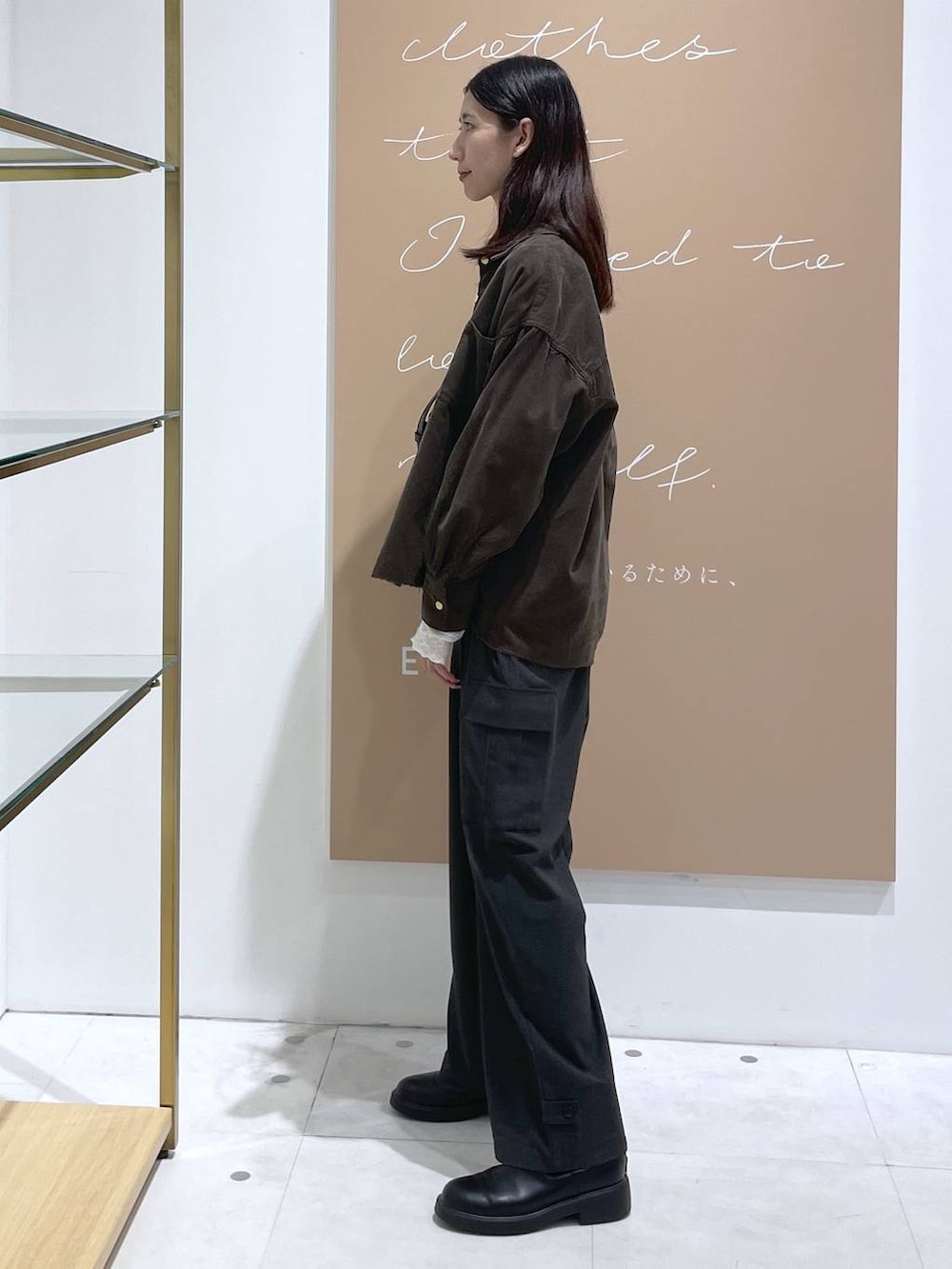 ブラック系のショルダーバッグ、グレー系のシャツ/ブラウス、ホワイト系のTシャツ/カットソーを着用したレディースの秋コーディネートの2枚目の写真