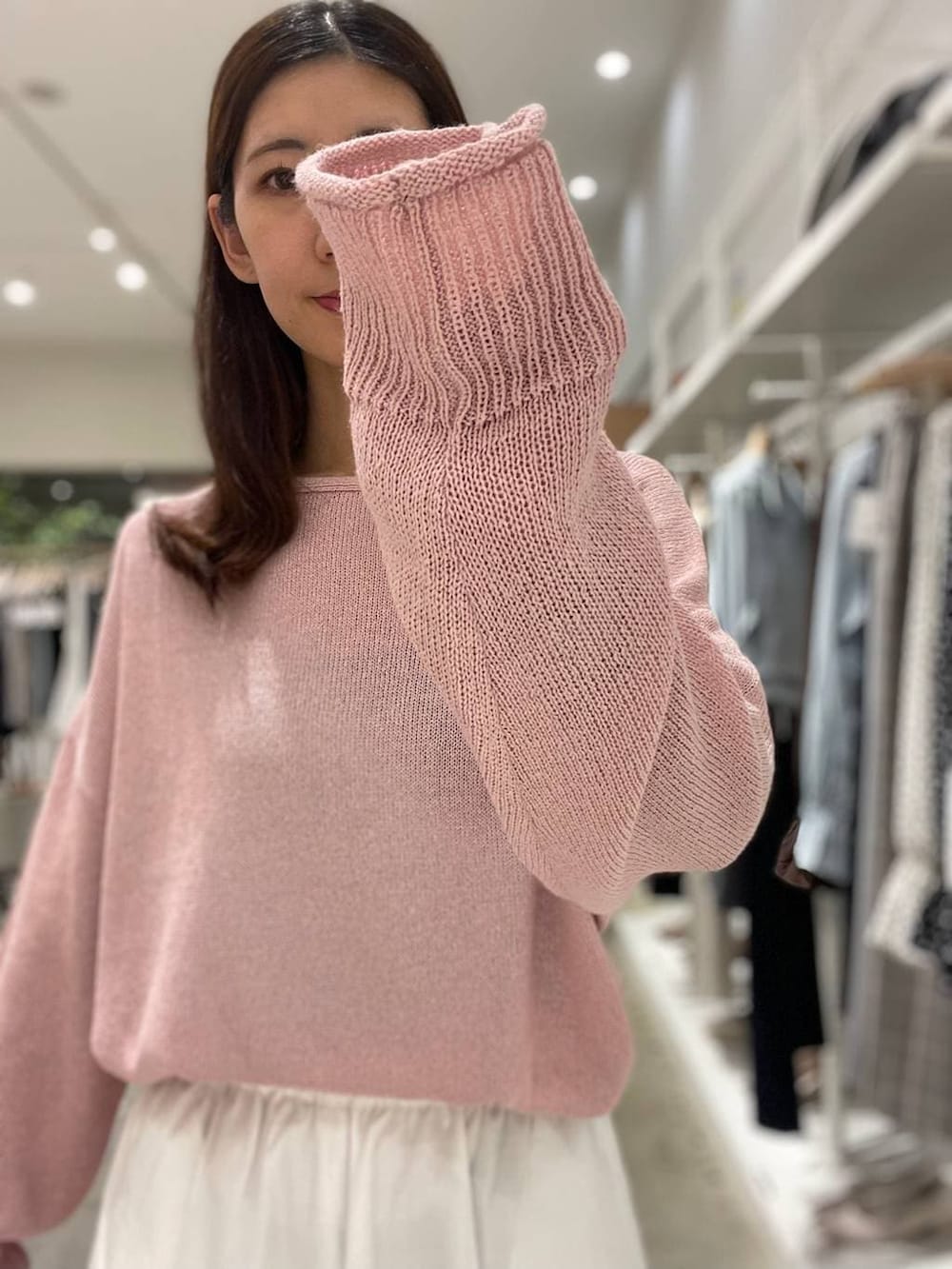 イエロー系のハンドバッグ、ピンク系のニット/セーター、ホワイト系のスカートを着用したレディースの春コーディネートの5枚目の写真