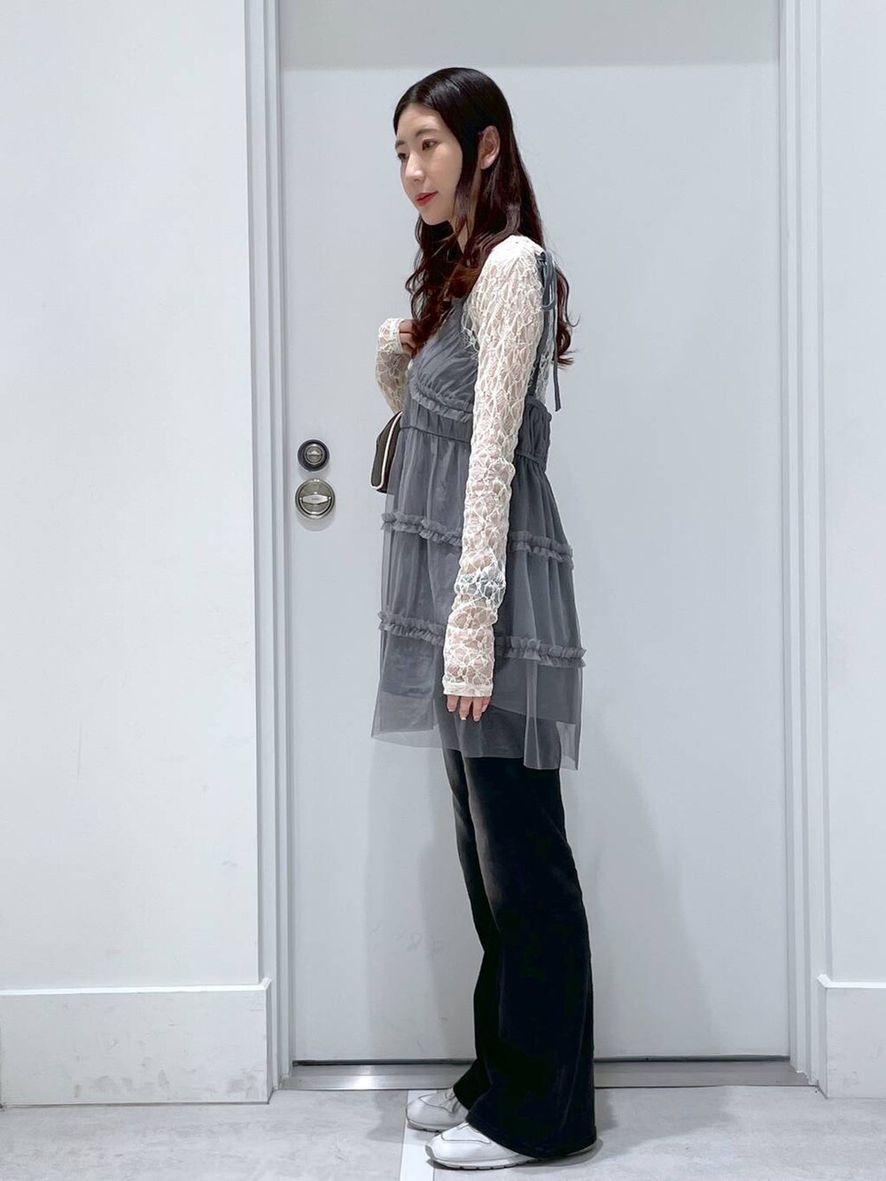 ブラック系のデニムパンツ、ホワイト系のTシャツ/カットソー、グレー系のチュニックを着用したレディースの春コーディネートの2枚目の写真