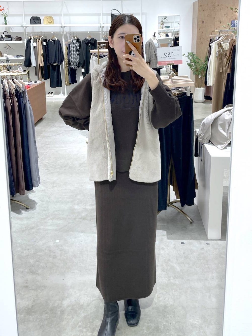 ブラウン系のTシャツ/カットソー、ブラウン系のスカート、ベージュ系のマウンテンパーカーを着用したレディースの秋コーディネートの3枚目の写真