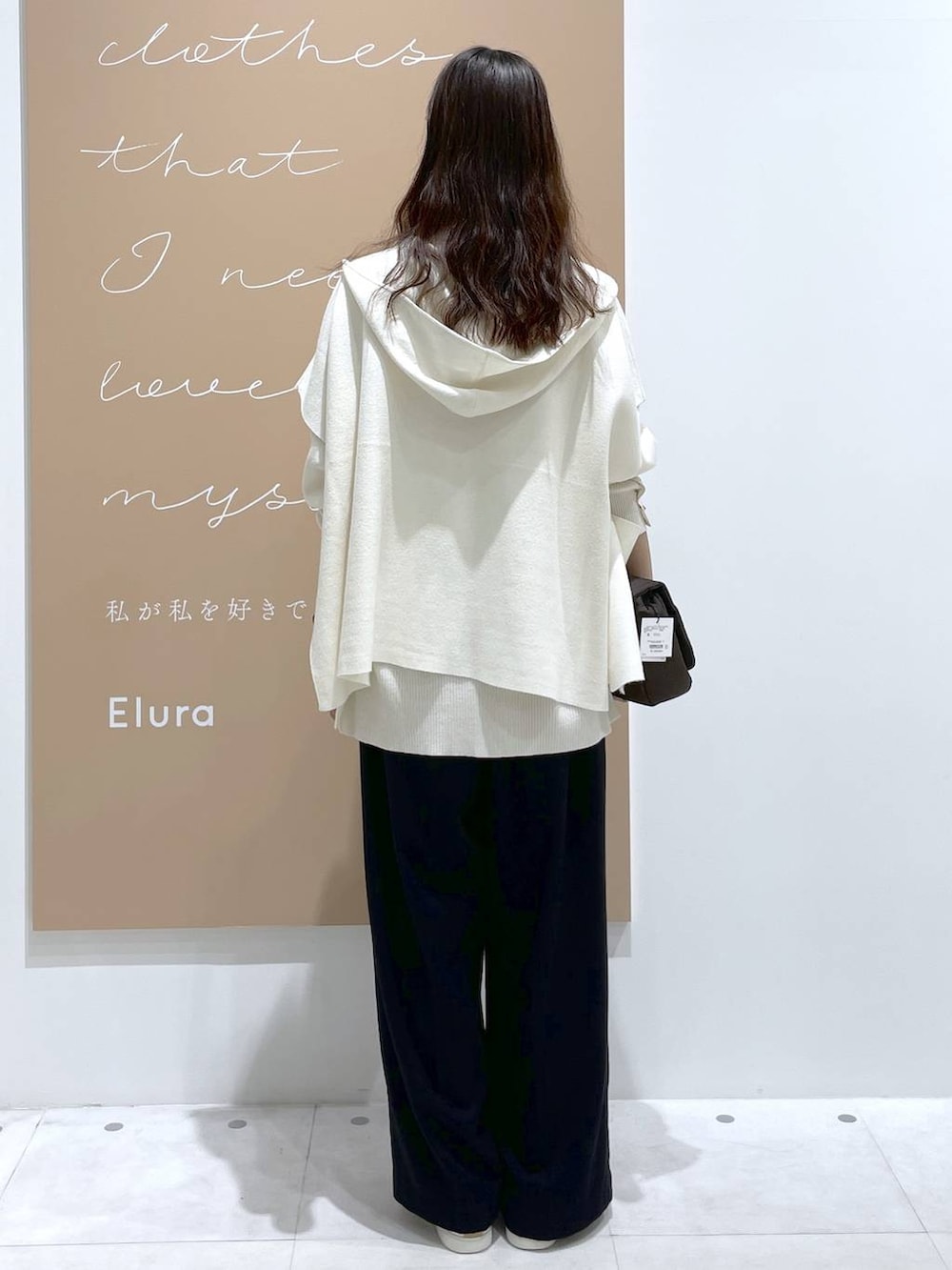 ブラック系のニット/セーター、ホワイト系のベスト、ブラウン系のショルダーバッグを着用したレディースの冬コーディネートの3枚目の写真