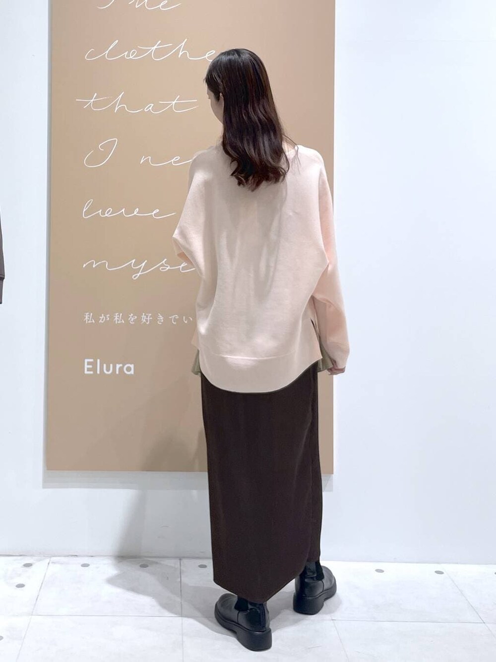 ブラウン系のスカート、ブラック系のハンドバッグ、ピンク系のニット/セーターを着用したレディースの春コーディネートの3枚目の写真