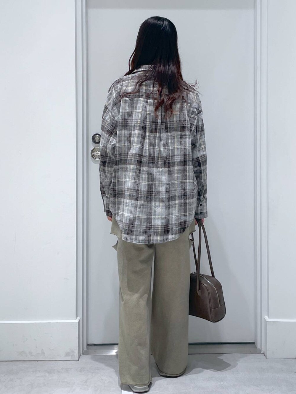 ブラウン系のショルダーバッグ、グレー系のシャツ/ブラウス、グリーン系のスウェットパンツを着用したレディースの冬コーディネートの3枚目の写真