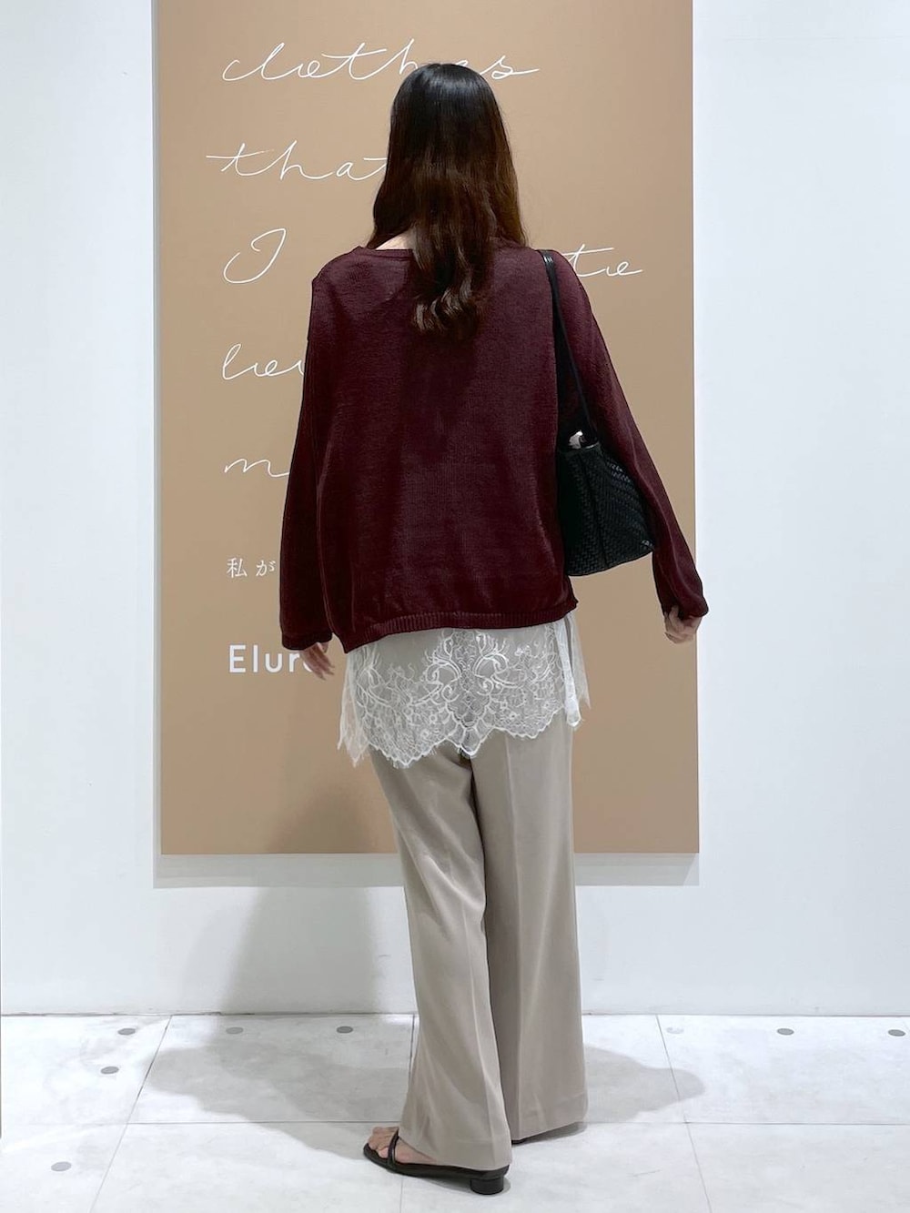 レッド系のニット/セーター、ブラック系のサンダル、ブラック系のトートバッグを着用したレディースの秋コーディネートの3枚目の写真
