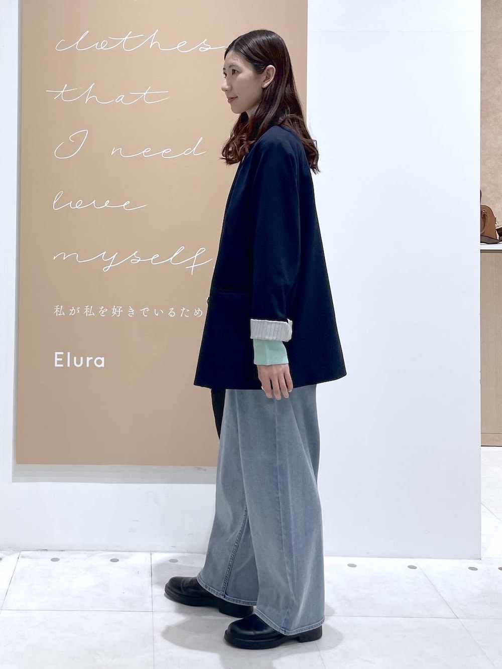 ホワイト系のタンクトップ、ブルー系のデニムパンツ、ブルー系のテーラードジャケットを着用したレディースの春コーディネートの3枚目の写真