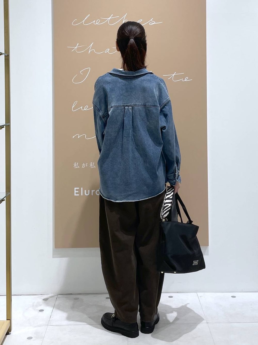 グレー系のその他パンツ、ホワイト系のニット/セーター、ブラック系のショルダーバッグを着用したレディースの秋コーディネートの3枚目の写真