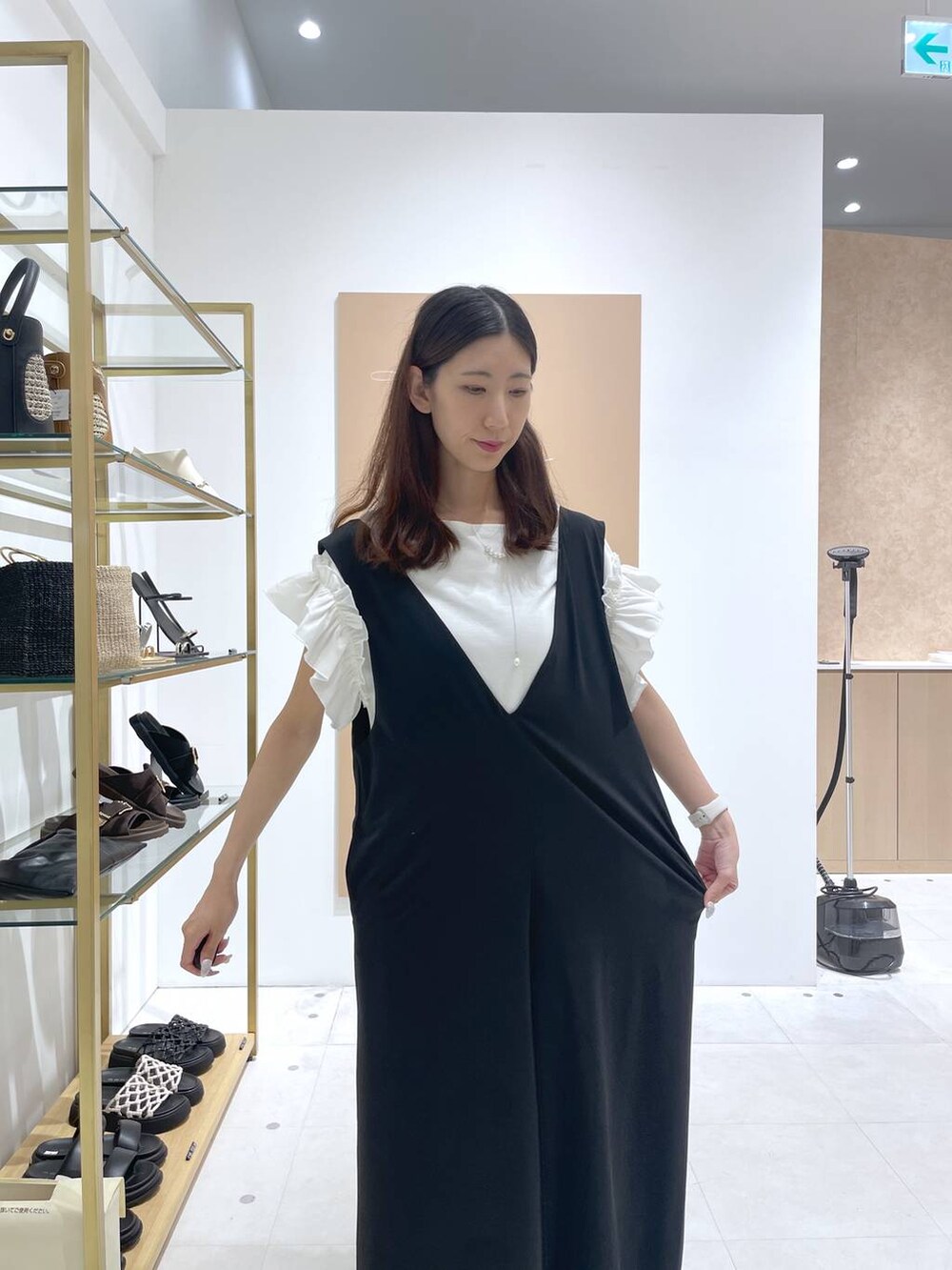 ブラック系のサロペット/オーバーオール、シルバー系のトートバッグ、ホワイト系のTシャツ/カットソーを着用したレディースの夏コーディネートの4枚目の写真