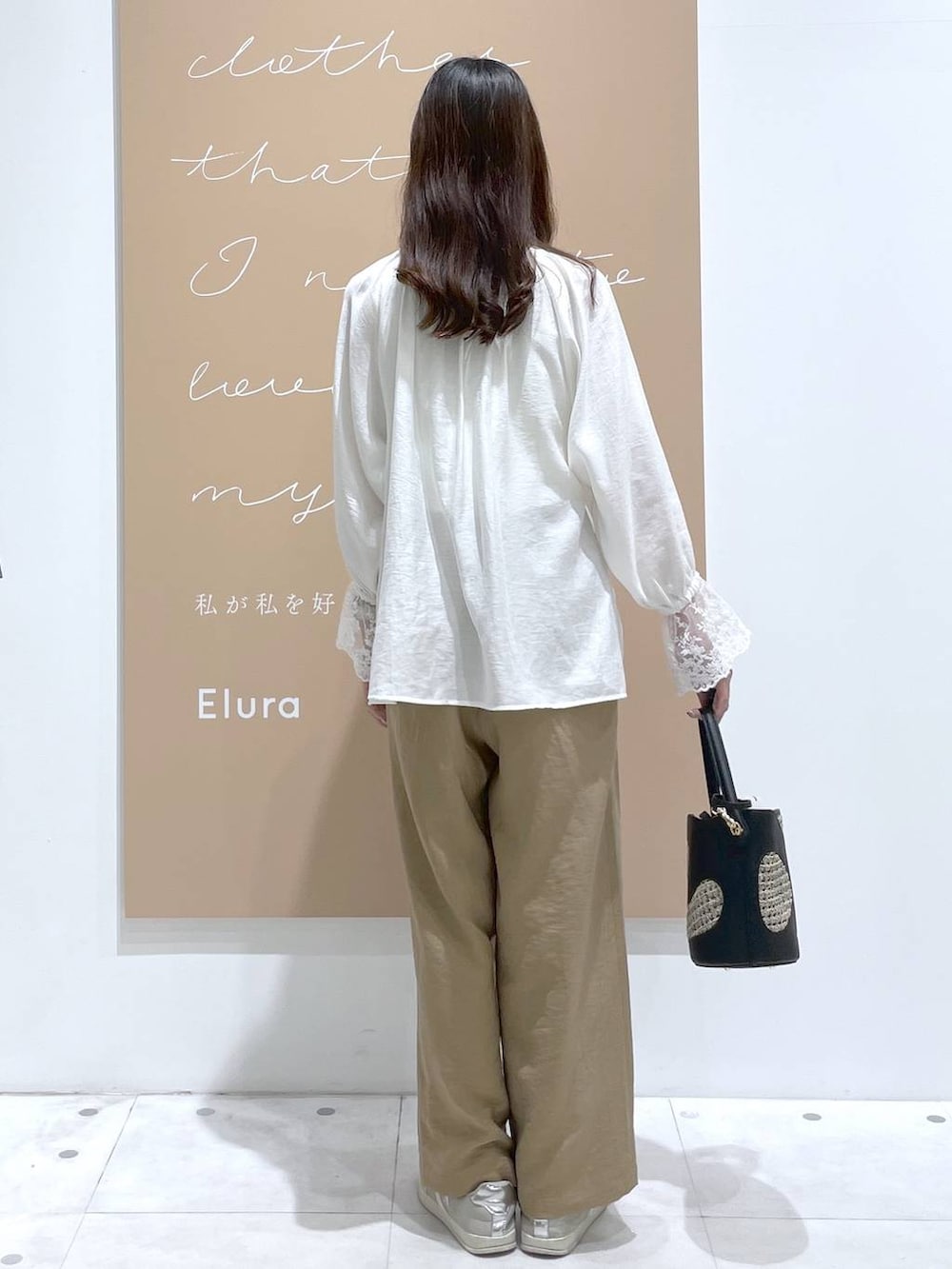 ブラック系のハンドバッグ、ベージュ系のその他パンツ、ホワイト系のシャツ/ブラウスを着用したレディースの春コーディネートの3枚目の写真