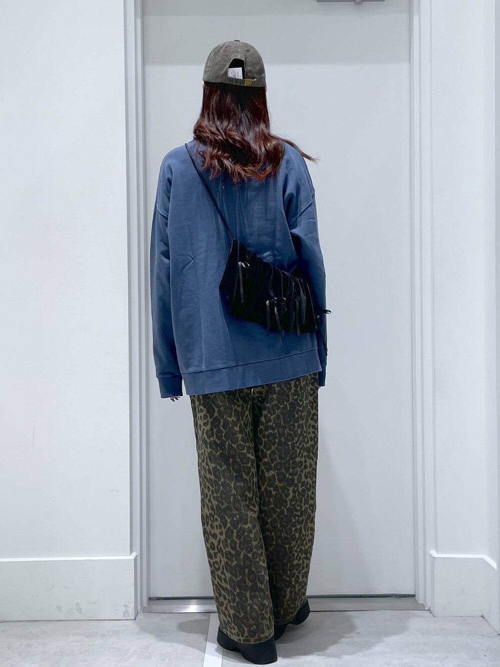 ブラック系のスリッポン、ブラック系のショルダーバッグ、ブルー系のスウェットを着用したレディースの冬コーディネートの3枚目の写真