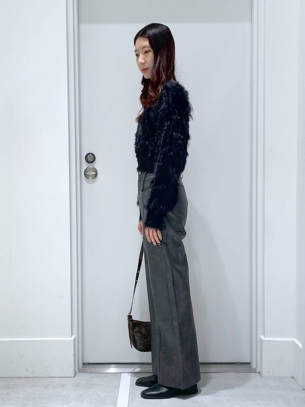 ブラック系のニット/セーター、ブラック系のその他パンツを着用したレディースの冬コーディネートの2枚目の写真