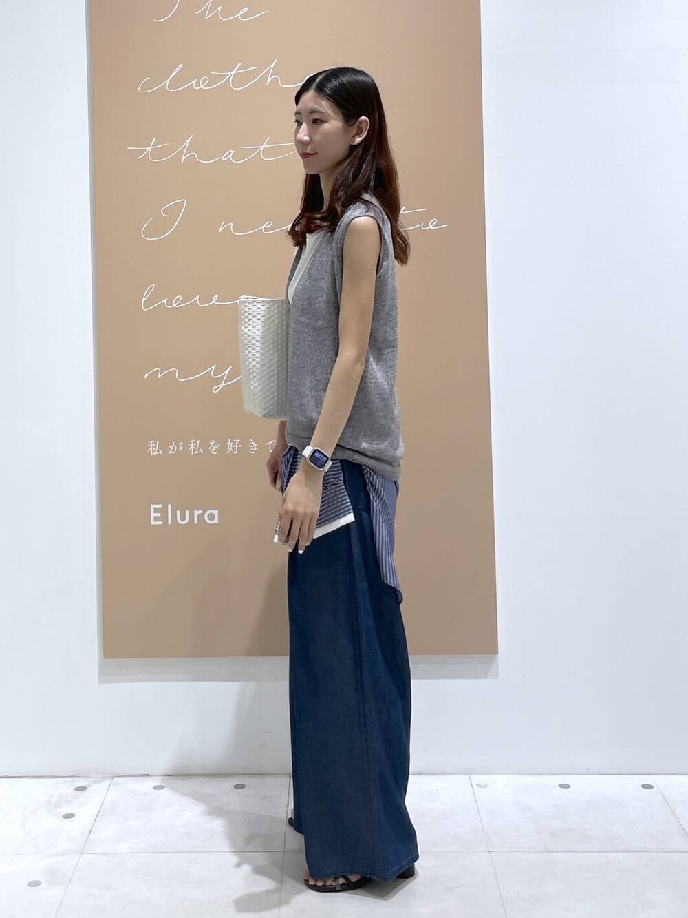ブルー系のデニムパンツ、ブルー系のシャツ/ブラウス、ホワイト系のかごバッグを着用したレディースの夏コーディネートの2枚目の写真