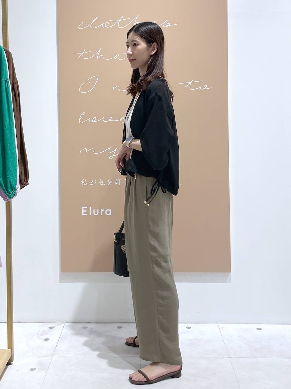 ホワイト系のその他パンツ、ホワイト系のタンクトップ、ブラック系のハンドバッグを着用したレディースの夏コーディネートの2枚目の写真