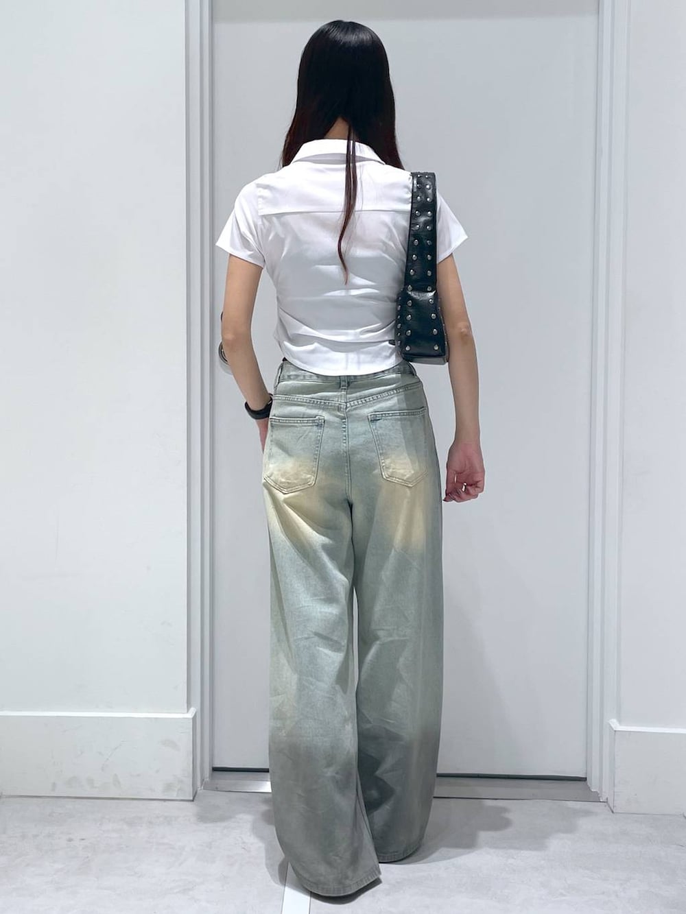 ホワイト系のシャツ/ブラウス、ブルー系のデニムパンツ、ブラウン系のハンドバッグを着用したレディースの夏コーディネートの3枚目の写真