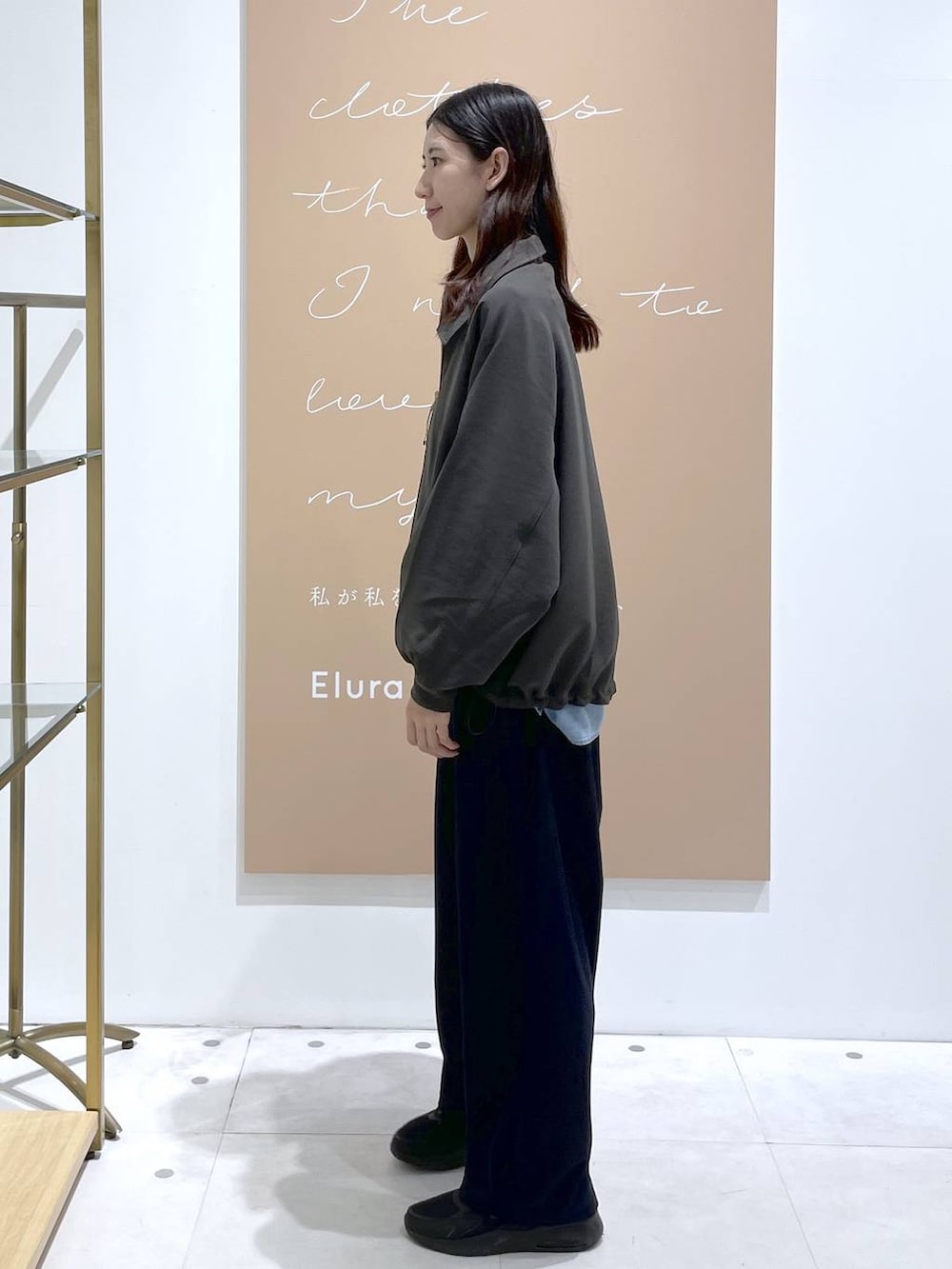 グレー系のブルゾン、ブルー系のその他パンツ、イエロー系のショルダーバッグを着用したレディースの秋コーディネートの2枚目の写真