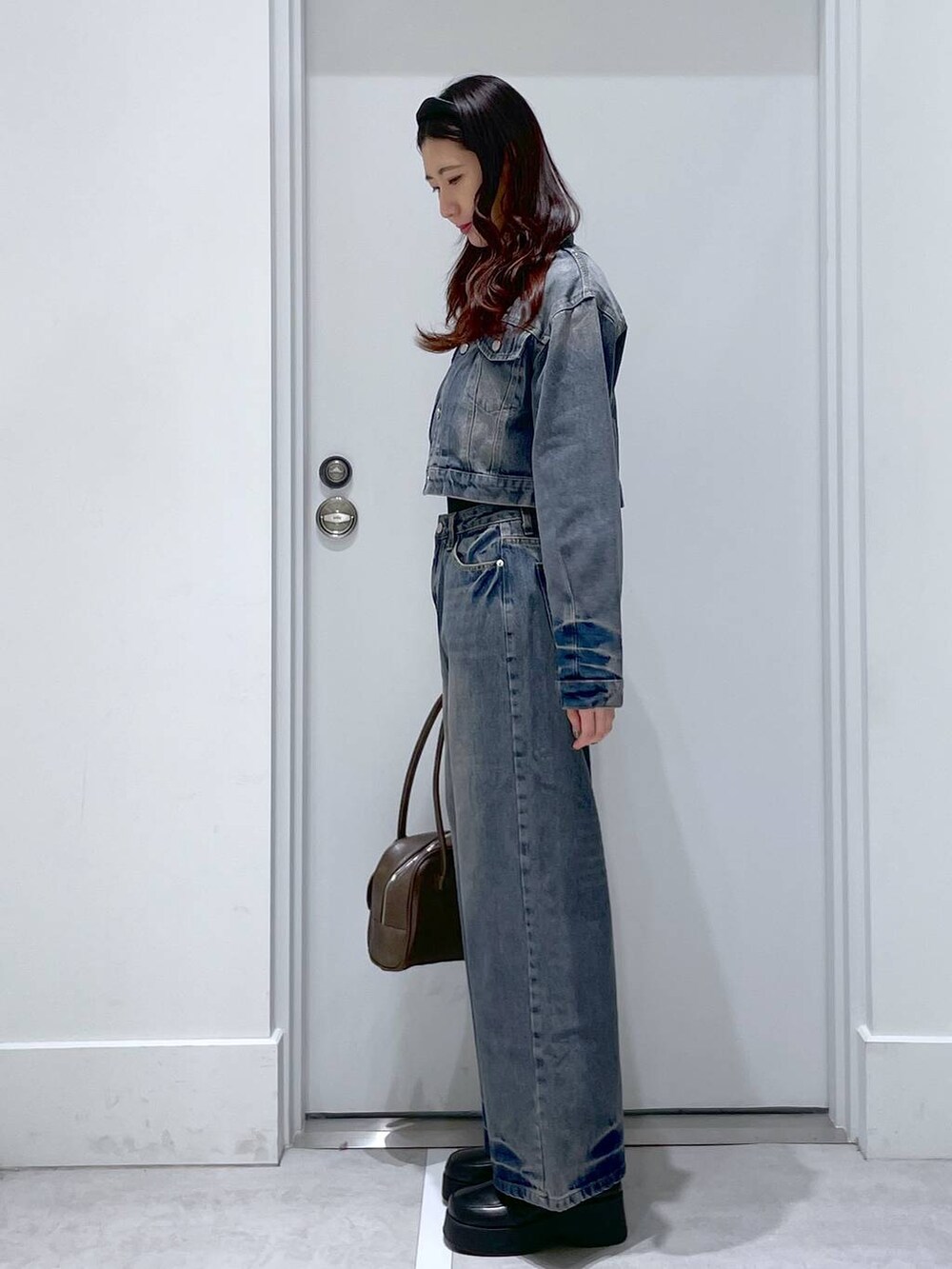 ブラック系のスリッポン、ブルー系のデニムパンツ、ブルー系のデニムジャケットを着用したレディースの冬コーディネートの2枚目の写真