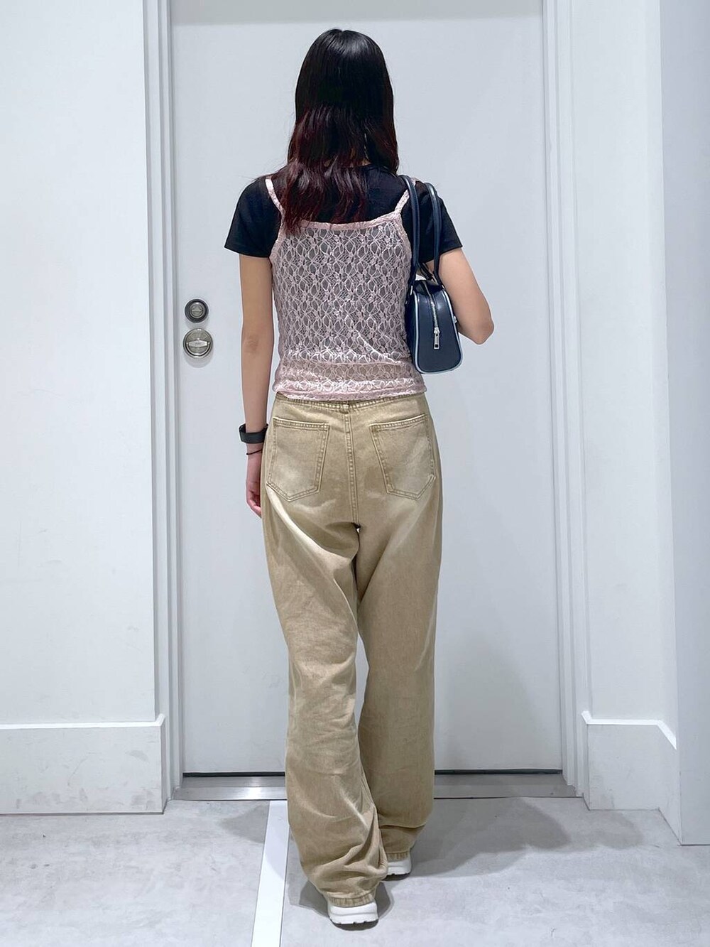 ブルー系のボストンバッグ、ブラック系のTシャツ/カットソー、ブラウン系のデニムパンツを着用したレディースの夏コーディネートの3枚目の写真