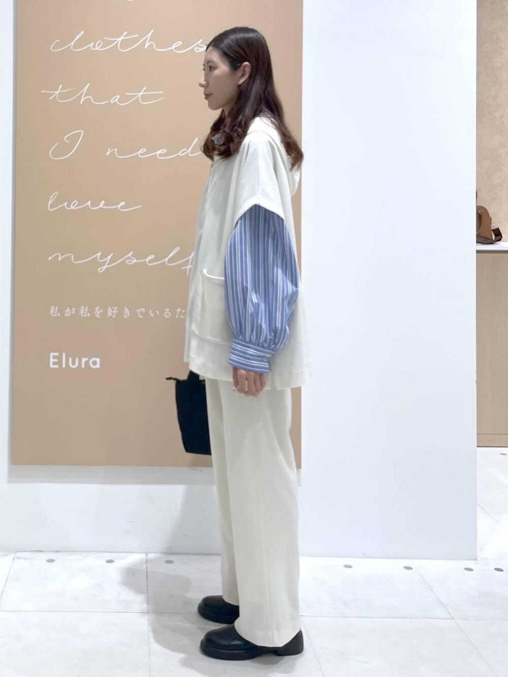 ホワイト系のその他パンツ、ブルー系のシャツ/ブラウス、ブラック系のショルダーバッグを着用したレディースの春コーディネートの2枚目の写真