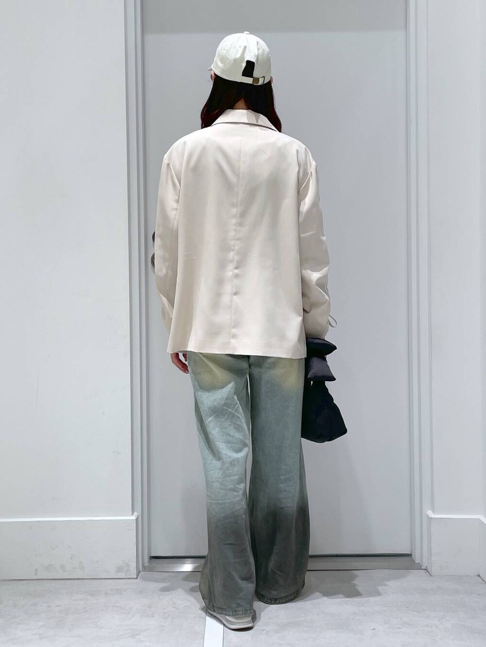ホワイト系のTシャツ/カットソー、ブラック系のハンドバッグ、ベージュ系のテーラードジャケットを着用したレディースの春コーディネートの3枚目の写真
