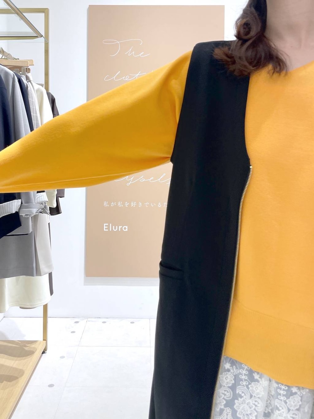 ベージュ系のトートバッグ、ホワイト系のタンクトップ、ブラック系のジャンパースカートを着用したレディースの春コーディネートの4枚目の写真