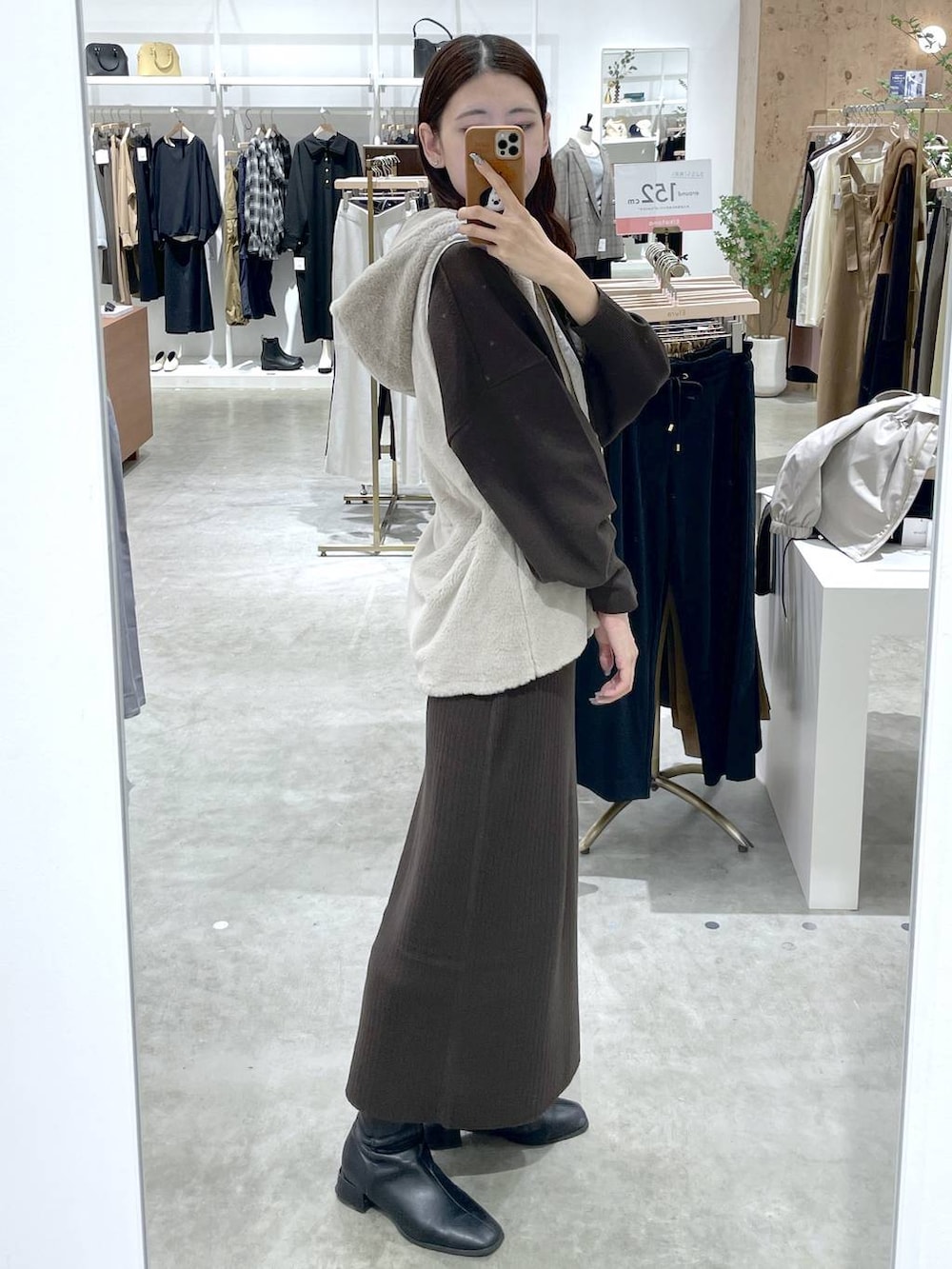 ブラウン系のTシャツ/カットソー、ブラウン系のスカート、ベージュ系のマウンテンパーカーを着用したレディースの秋コーディネートの4枚目の写真