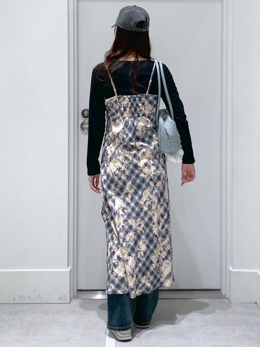 ブルー系のデニムパンツ、ブルー系のショルダーバッグ、ブルー系のワンピースを着用したレディースの春コーディネートの3枚目の写真