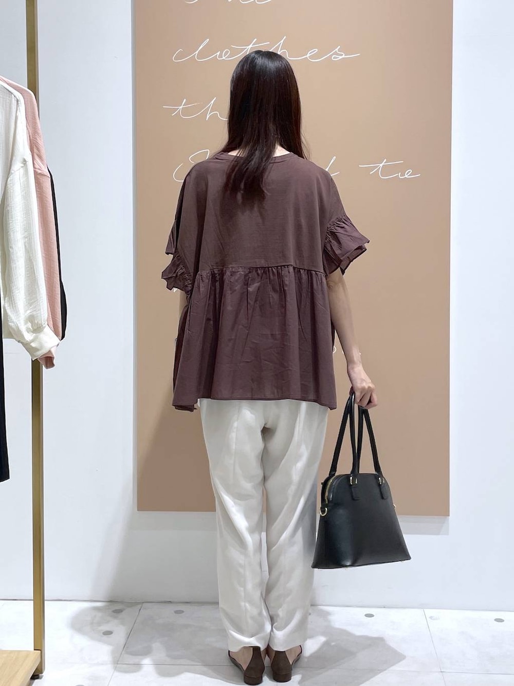 ブラウン系のTシャツ/カットソー、ブラック系のハンドバッグ、ブラック系のサンダルを着用したレディースの春コーディネートの3枚目の写真