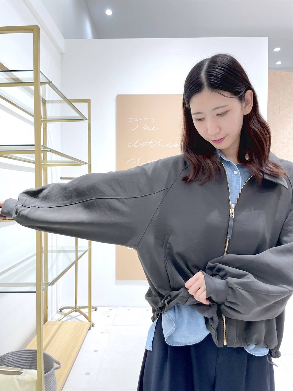 グレー系のブルゾン、ブルー系のその他パンツ、イエロー系のショルダーバッグを着用したレディースの秋コーディネートの4枚目の写真
