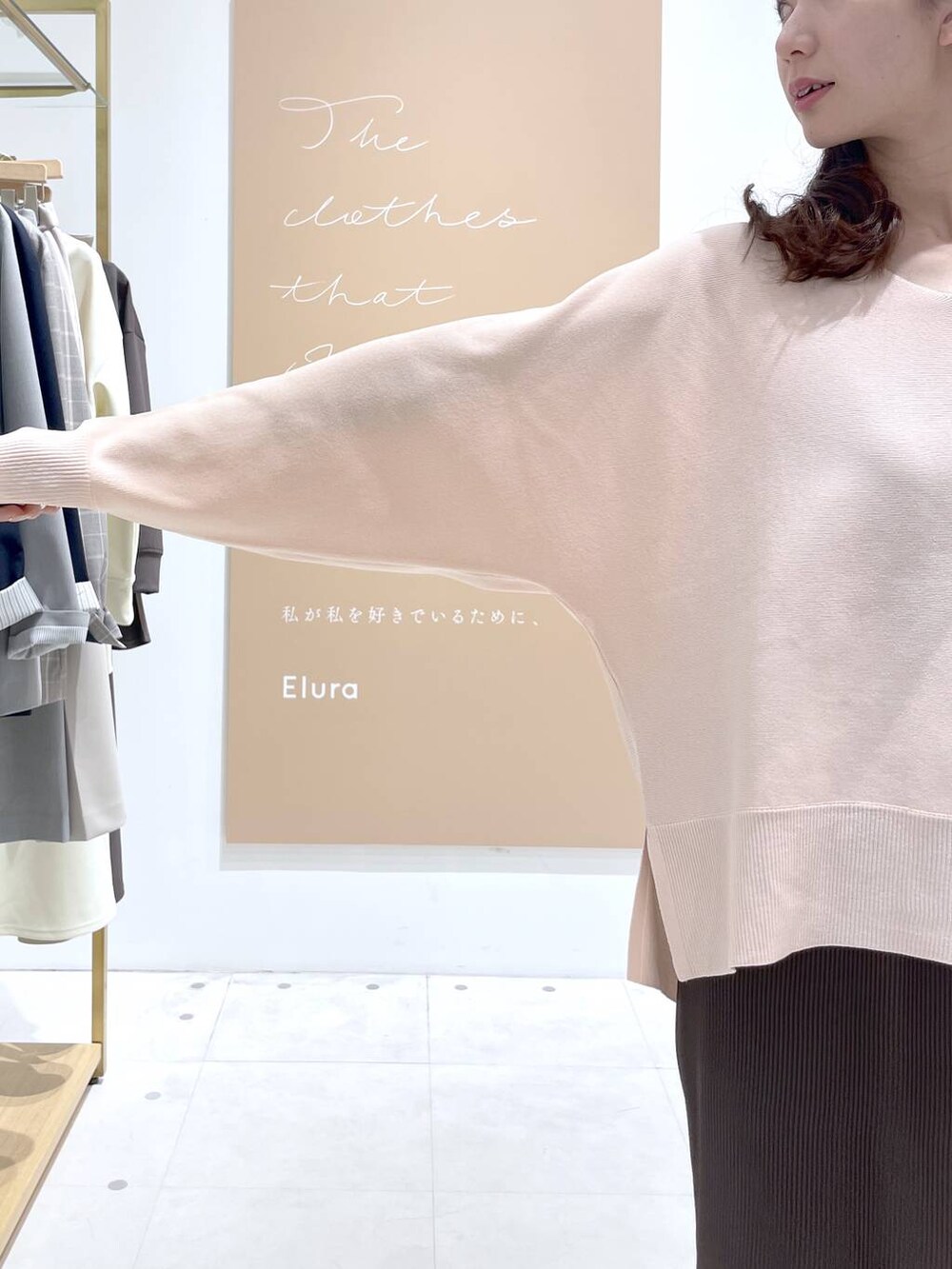 ブラウン系のスカート、ブラック系のハンドバッグ、ピンク系のニット/セーターを着用したレディースの春コーディネートの4枚目の写真