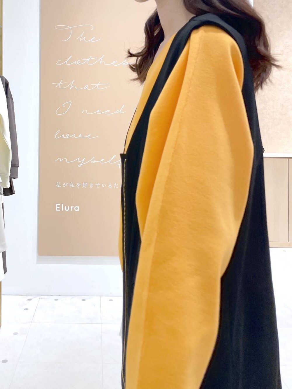 ベージュ系のトートバッグ、ホワイト系のタンクトップ、ブラック系のジャンパースカートを着用したレディースの春コーディネートの5枚目の写真